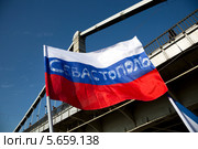 Флаг с надписью "Севастополь" около Крымского моста на митинге в поддержку Крыма и русскоязычных жителей Украины в городе Москве 01 марта 2014. Стоковое фото, фотограф Николай Винокуров / Фотобанк Лори