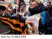 Девушка с георгиевской лентой и портретом президента Владимира Путина на шествии в поддержку соотечественников на Украине, Москва (2014 год). Редакционное фото, фотограф Николай Винокуров / Фотобанк Лори
