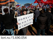 Мужчина держит плакат "Донбасс против фашизма" на митинге в поддержку русских на Украине в Новопушкинском сквере города Москвы 10 марта 2014. Редакционное фото, фотограф Николай Винокуров / Фотобанк Лори