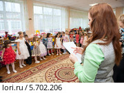 Воспитательница говорит детям напутственное слово перед выступлением на сцене (2014 год). Редакционное фото, фотограф Кекяляйнен Андрей / Фотобанк Лори