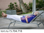 мужчина отдыхает, лежа на шезлонге. Стоковое фото, фотограф Phovoir Images / Фотобанк Лори