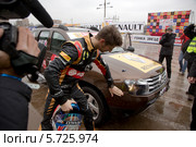 Пилот Формулы 1 Ромен  Грожан (команда Lotus F1 Team) показывает повреждения на в автомобиле Дастер, которые он получил на ледяной трассе "Гонки звезд" на приз журнала "За рулем" 23 февраля 2014. Редакционное фото, фотограф Николай Винокуров / Фотобанк Лори