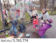 Дети пускают мыльные пузыри в городском саду. 1 апреля. "Юморина" в Одессе (2014 год). Редакционное фото, фотограф KEN VOSAR / Фотобанк Лори
