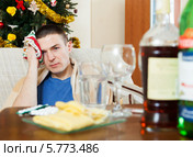 Мужчина мучается от головной боли и держит шарф у возле головы. Стоковое фото, фотограф Яков Филимонов / Фотобанк Лори