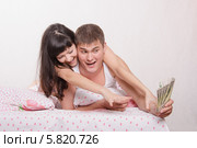 Жена отнимает деньги у мужа, лежа в постели. Стоковое фото, фотограф Иванов Алексей / Фотобанк Лори