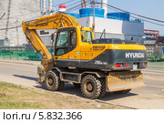 Современный колёсный экскаватор HYUNDAI R-210W-9S («Хёндэ») на улице на фоне ТЭЦ-16 ОАО «Мосэнерго» в Москве (2014 год). Редакционное фото, фотограф Владимир Сергеев / Фотобанк Лори