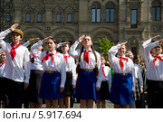 Пионеры салюту на всероссийской торжественной линейке, посвященной Дню пионерии и приему в пионеры на Красной площади города Москвы (2014 год). Редакционное фото, фотограф Николай Винокуров / Фотобанк Лори