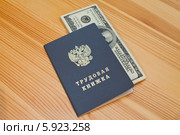 Трудовая книжка гражданина Российской Федерации с вложенной пачкой 100-долларовых купюр. Стоковое фото, фотограф Александр Тарасенков / Фотобанк Лори