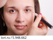 Визажист наносит тональный крем на веки молодой девушки. Стоковое фото, фотограф Иванов Алексей / Фотобанк Лори