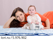 Мама с шестимесячной дочкой играют на кровати. Стоковое фото, фотограф Иванов Алексей / Фотобанк Лори