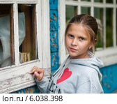 Девочка-подросток стоит возле окна старого дома (2014 год). Редакционное фото, фотограф Игорь Низов / Фотобанк Лори