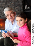 Old man playing card game with his granddaughter. Стоковое фото, фотограф Phovoir Images / Фотобанк Лори