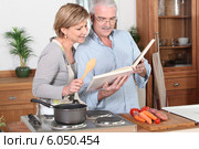 Couple reading a recipe book. Стоковое фото, фотограф Phovoir Images / Фотобанк Лори