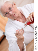 Old woman drinking cough syrup. Стоковое фото, фотограф Phovoir Images / Фотобанк Лори