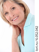 mature blonde woman wearing a turquoise polo shirt having a large smile. Стоковое фото, фотограф Phovoir Images / Фотобанк Лори
