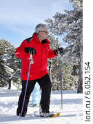 Older man walking in snow shoes. Стоковое фото, фотограф Phovoir Images / Фотобанк Лори