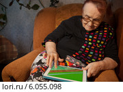 Пожилая женщина с планшетным компьютером на коленях. Стоковое фото, фотограф Данил Руденко / Фотобанк Лори