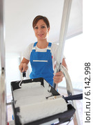 Female decorator climbing ladder. Стоковое фото, фотограф Phovoir Images / Фотобанк Лори
