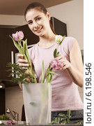 Young woman arranging flowers in the vase. Стоковое фото, агентство BE&W Photo / Фотобанк Лори