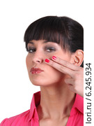 Brunette holding two finger to face. Стоковое фото, фотограф Phovoir Images / Фотобанк Лори