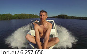 Мужчина едет на носу моторной лодки по озеру. Стоковое видео, видеограф Кекяляйнен Андрей / Фотобанк Лори