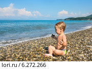 Маленький мальчик сидит в позе лотоса на пляже и смотрит на море. Стоковое фото, фотограф Светлана Кузнецова / Фотобанк Лори