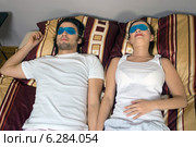 Woman and man lying on bed with eye compresses. Стоковое фото, агентство BE&W Photo / Фотобанк Лори