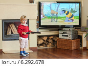 A child watching tv at home. Редакционное фото, агентство BE&W Photo / Фотобанк Лори