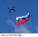Радиоуправляемый беспилотный летательный аппарат - гексокоптер несет флаг России. Стоковое фото, фотограф SevenOne / Фотобанк Лори