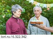 Пожилая пара с именинным пирогом со свечами. Стоковое фото, фотограф Юлия Кузнецова / Фотобанк Лори