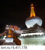 Low angle view of a stupa with Potala Palace in the background, Lhasa, Tibet, China (2012 год). Стоковое фото, агентство Ingram Publishing / Фотобанк Лори