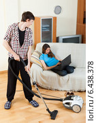 Guy doing house cleaning during girl resting. Стоковое фото, фотограф Яков Филимонов / Фотобанк Лори