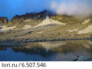 Скалы, освещённые рассветным солнцем, и небольшое моренное озеро на высоте 3400 метров около перевала Южный Белаг, в Дигории, Республика Северная Осетия-Алания. Стоковое фото, фотограф Михаил Марковский / Фотобанк Лори