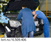 Рабочие монтируют детали в подкапотном пространстве автомобиля. Автомобильный завод (2014 год). Редакционное фото, фотограф Ирина Борсученко / Фотобанк Лори