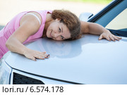 Счастливая девушка прижимается к капоту автомобиля. Стоковое фото, фотограф Кекяляйнен Андрей / Фотобанк Лори