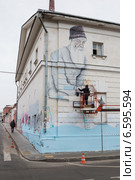 Художник рисует граффити на фасаде здания (2014 год). Редакционное фото, фотограф Родион Власов / Фотобанк Лори
