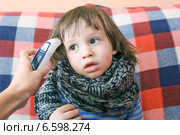 Двухлетнему малышу измеряют температуру инфракрасным термометром. Стоковое фото, фотограф ivolodina / Фотобанк Лори