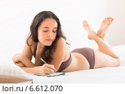 Brunette girl writing in notebok. Стоковое фото, фотограф Яков Филимонов / Фотобанк Лори