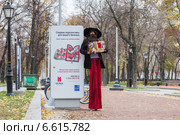 Артист ходульной мастерской "Высокое искусство" возле рекламного стенда (2014 год). Редакционное фото, фотограф Алексей Шматков / Фотобанк Лори
