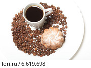 Чашка кофе среди кофейных зерен и кекс с изюмом на белом фоне. Стоковое фото, фотограф Яна Королёва / Фотобанк Лори