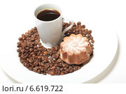 Чашка кофе среди кофейных зерен и кекс с изюмом на белом фоне. Стоковое фото, фотограф Яна Королёва / Фотобанк Лори