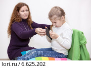 Безопасность детей в интернете, ребенок увидел запрещенный контент, мама отбирает смартфон. Стоковое фото, фотограф Кекяляйнен Андрей / Фотобанк Лори