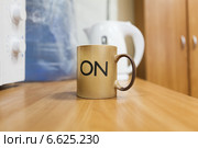 Чашка с надписью ON стоит на столе. Стоковое фото, фотограф Кекяляйнен Андрей / Фотобанк Лори
