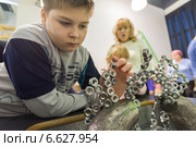 Мальчик в "Экспериментаниуме" в Москве. Опыт с магнитами (2014 год). Редакционное фото, фотограф Володина Ольга / Фотобанк Лори