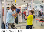 Отец с сыном боксируют в спортзале (2014 год). Редакционное фото, фотограф Володина Ольга / Фотобанк Лори