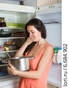 woman holding foul food near refrigerator. Стоковое фото, фотограф Яков Филимонов / Фотобанк Лори