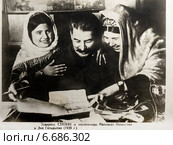 И.В.Сталин подписывает фотоснимки совещания передовиков сельского хозяйства с руководителями партии и правительства в подарок знатным колхозницам Эне Гельдыевой и пионерке Мамлахат Наханговой (2014 год). Стоковое фото, фотограф Николай Винокуров / Фотобанк Лори