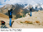 Туристы с рюкзаками фотографируют друг друга на вершины горы. Стоковое фото, фотограф Roman Barelko / Фотобанк Лори