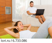 woman training on mat and inert guy resting. Стоковое фото, фотограф Яков Филимонов / Фотобанк Лори