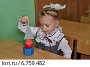 Девочка в классе смотрит на геометрические фигуры. Стоковое фото, фотограф Илюхина Наталья / Фотобанк Лори
